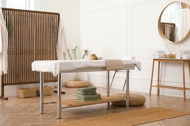 Photo of Stylish room interior with massage table in spa salon