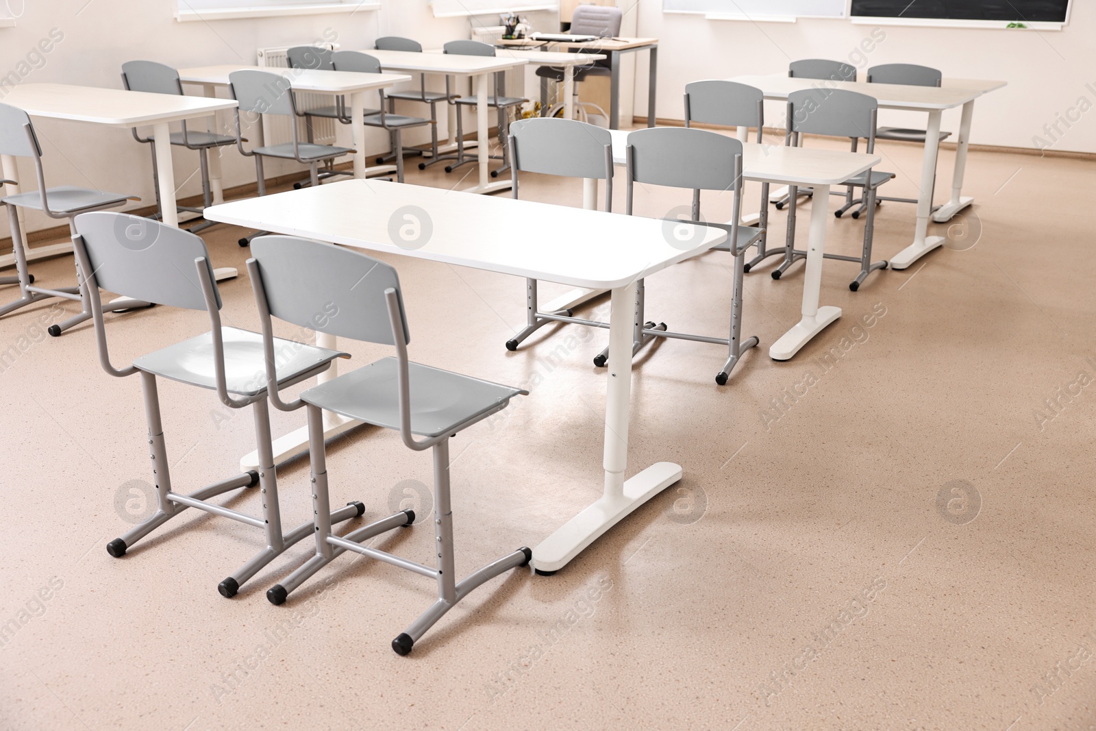 Photo of Empty school classroom with desks and chairs