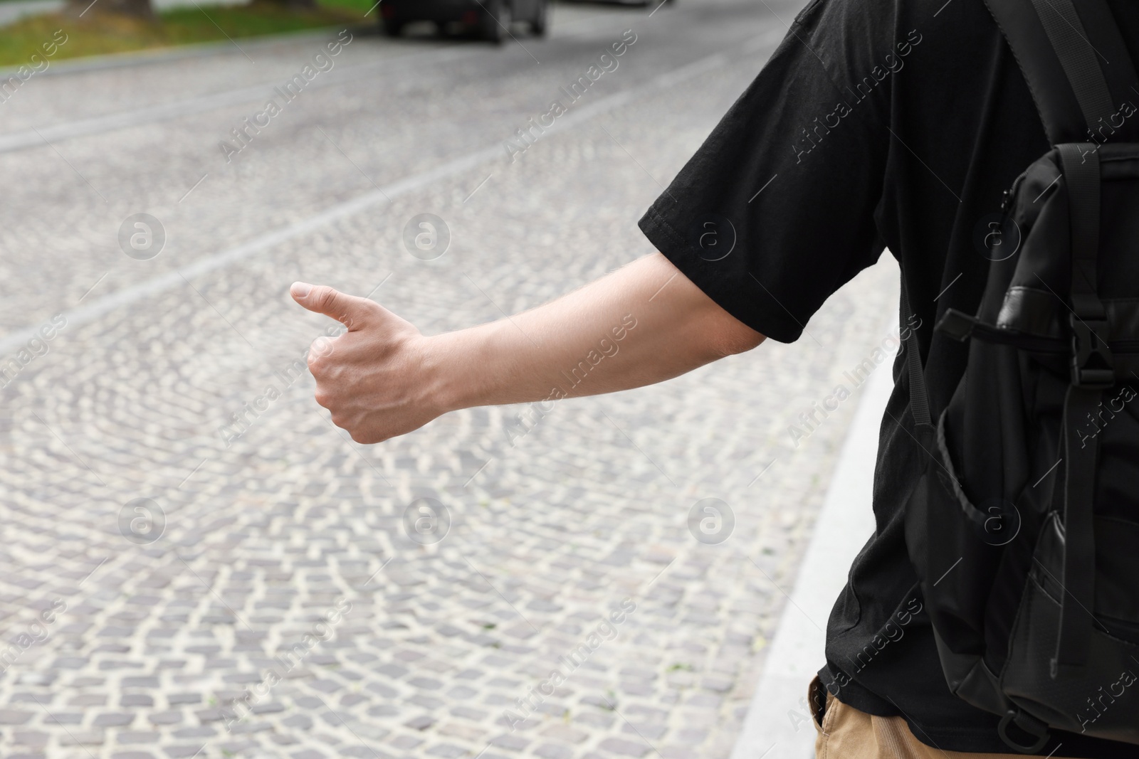 Photo of Man catching car on road, closeup. Hitchhiking trip