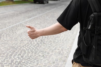 Photo of Man catching car on road, closeup. Hitchhiking trip