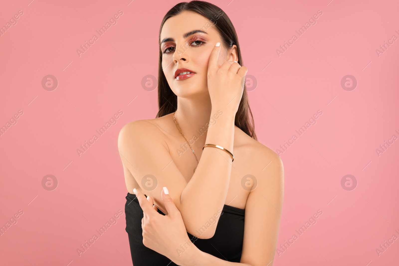 Photo of Beautiful woman with elegant jewelry on pink background