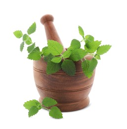 Photo of Wooden mortar with pestle and fresh green lemon balm leaves isolated on white