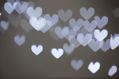 Photo of Blurred view of beautiful heart shaped lights on gray background
