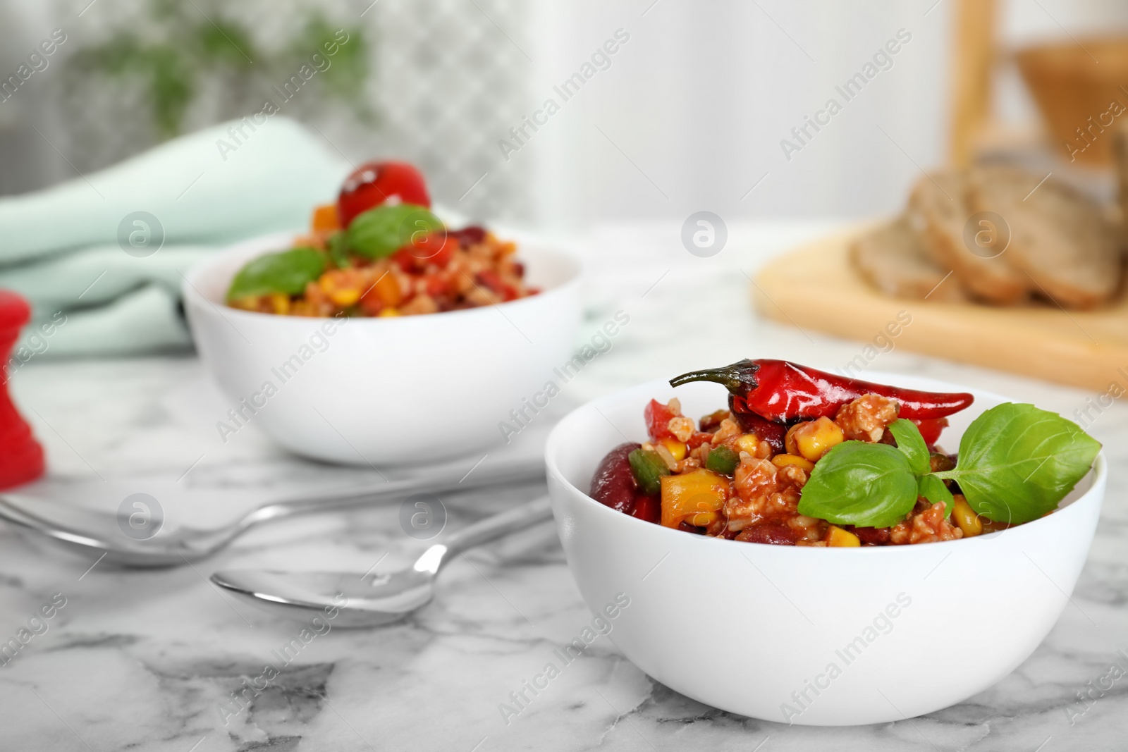 Photo of Tasty chili con carne served on marble table. Space for text