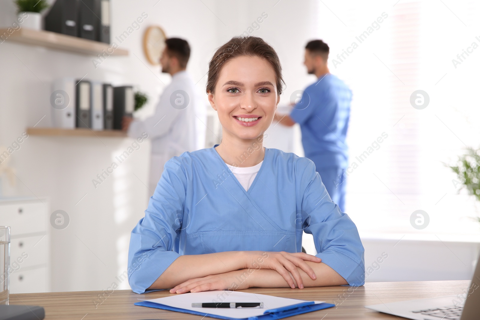 Photo of Portrait of female doctor at table in modern clinic