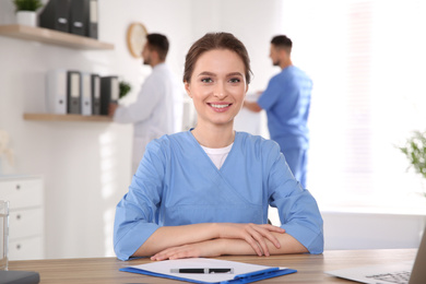 Photo of Portrait of female doctor at table in modern clinic