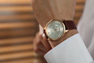 Photo of Man with luxury wrist watch on blurred background, closeup