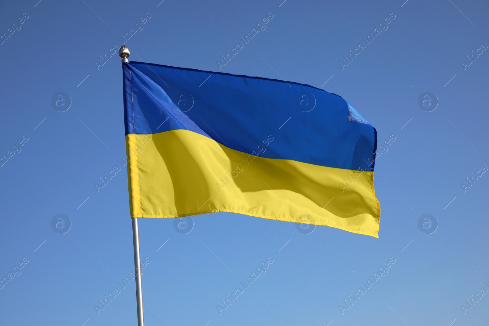 Photo of National flag of Ukraine against blue sky