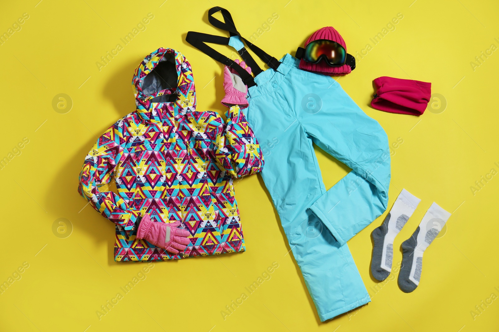 Photo of Stylish winter sport clothes on yellow background, flat lay
