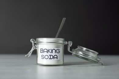 Photo of Open jar with baking soda on grey table