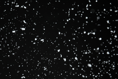 Photo of White snow falling down on black background