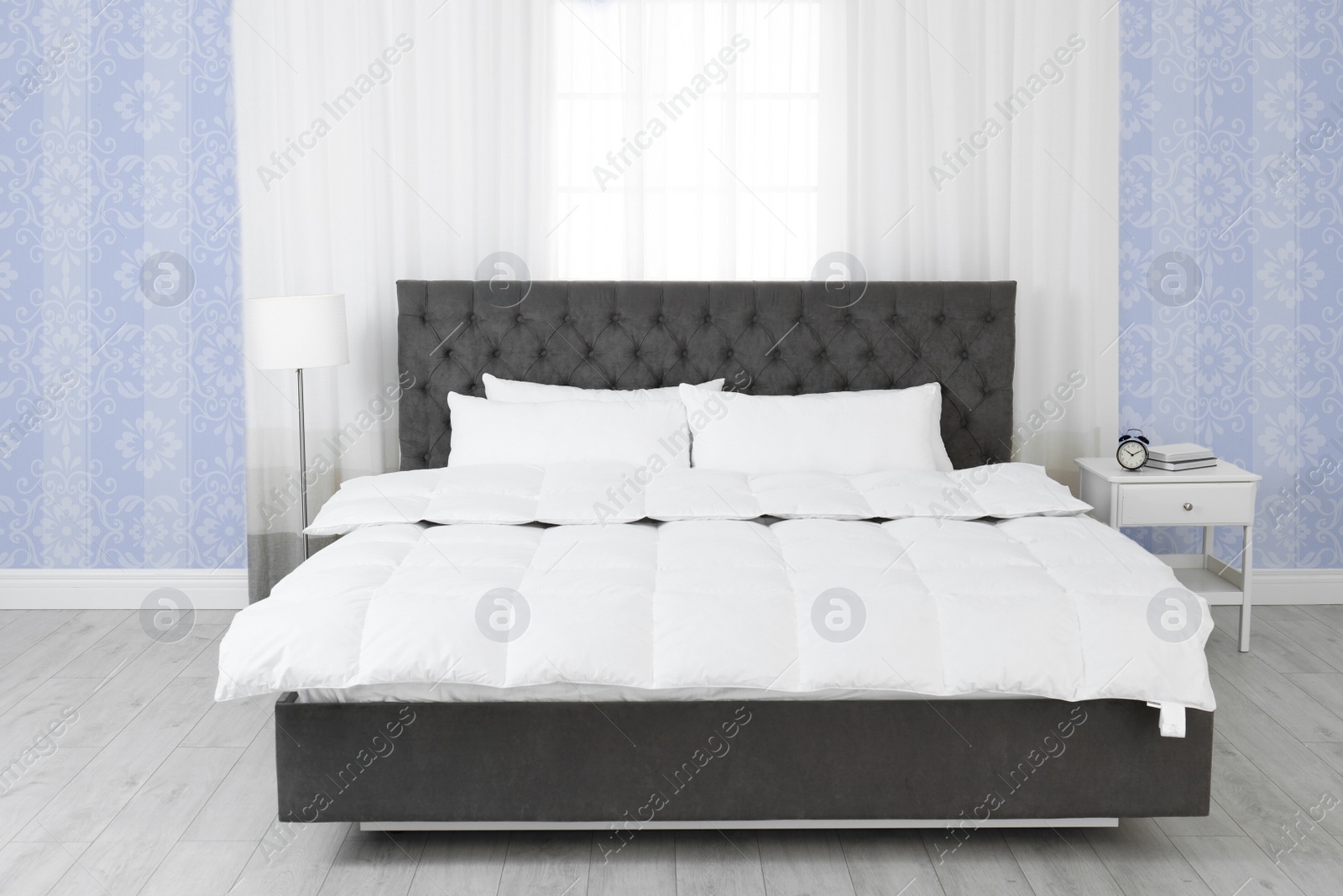 Image of Modern bedroom interior with furniture near patterned wallpapers
