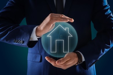 Mortgage rate. Man holding illustration of house on dark background, closeup