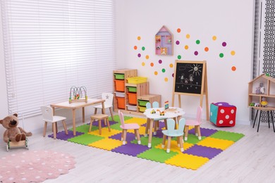 Stylish kindergarten interior with toys and modern furniture