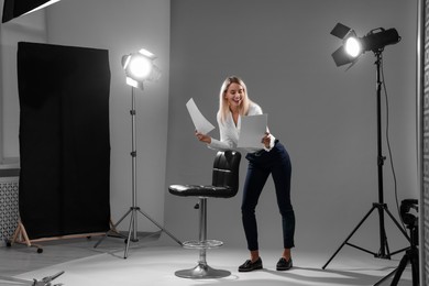 Photo of Casting call. Emotional woman performing against grey background in studio