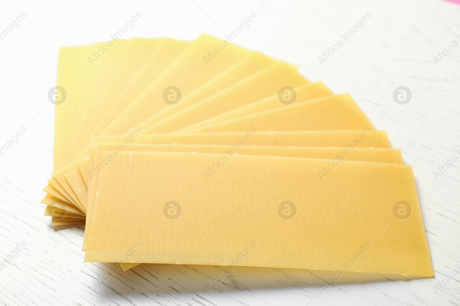 Photo of Uncooked lasagna sheets on white wooden table