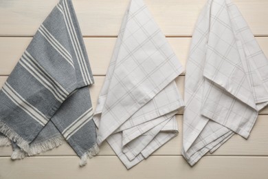 Photo of Different kitchen towels hanging on white wooden wall