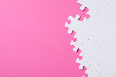 Photo of Blank white puzzle pieces on pink background, flat lay. Space for text