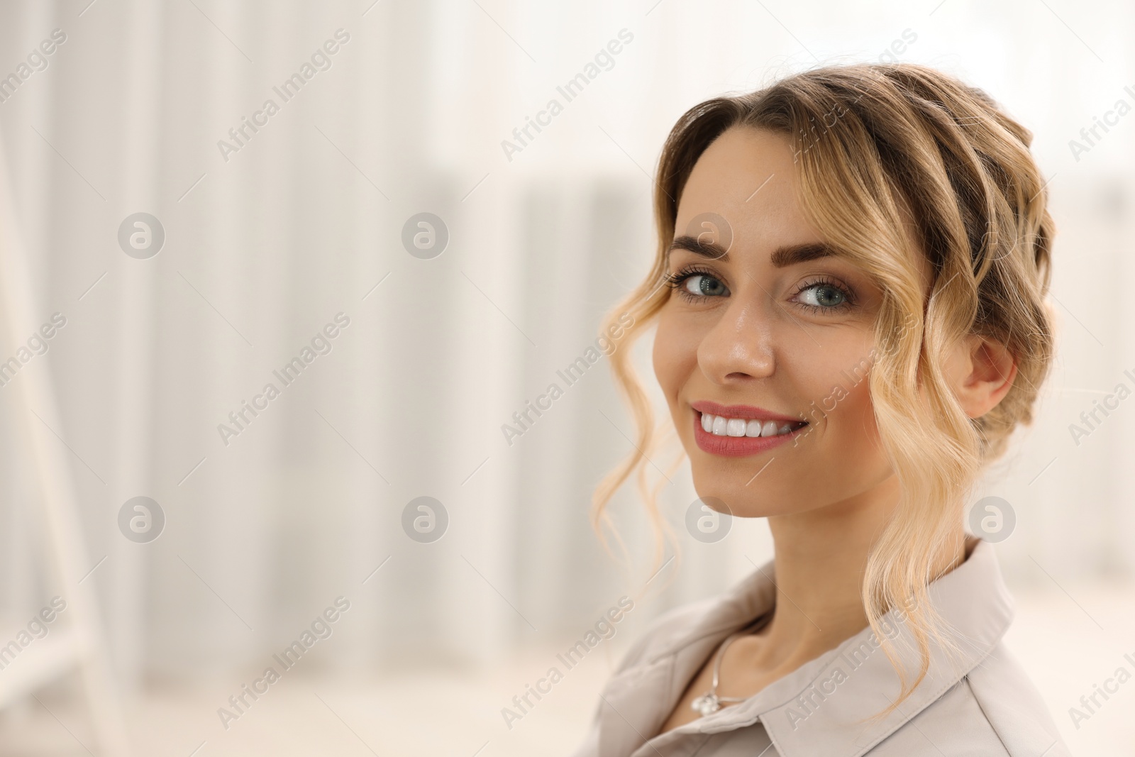 Photo of Portrait of smiling woman with beautiful hair style indoors. Space for text