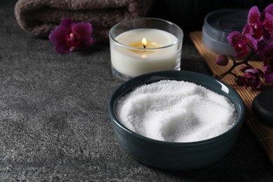 Photo of Beautiful composition with sea salt, burning candle, flowers and different spa products on grey table, space for text