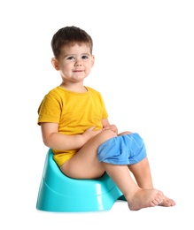 Photo of Portrait of little boy sitting on potty against white background