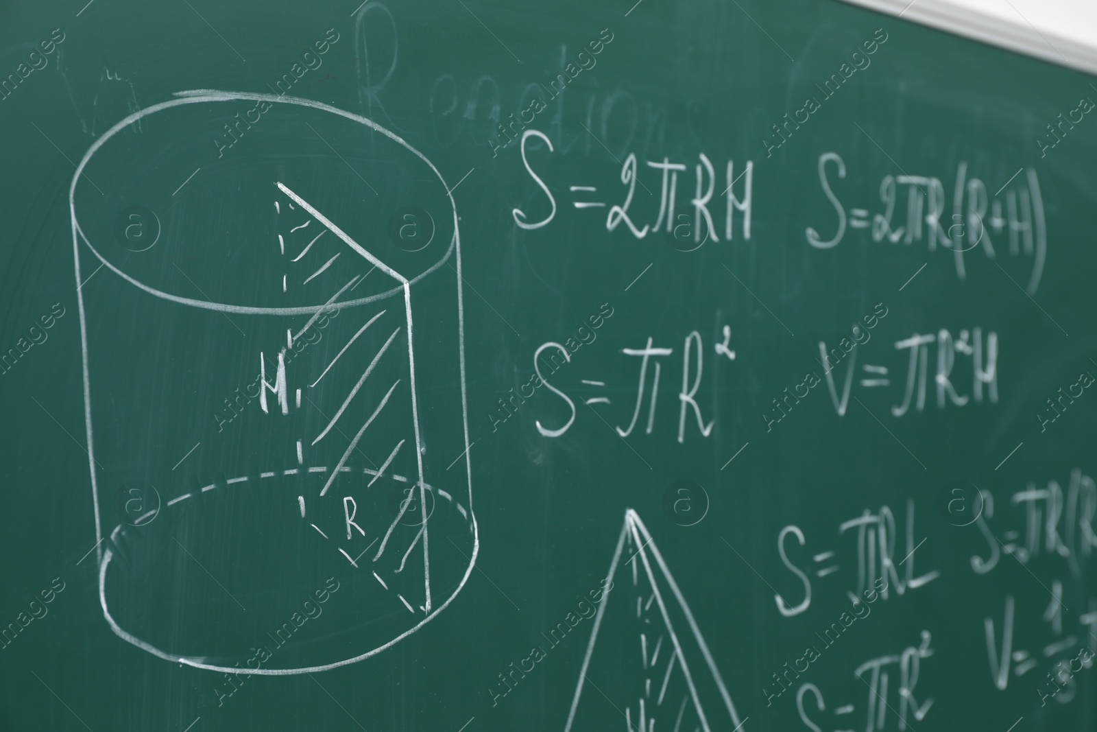 Photo of Different math formulas written with chalk on green board