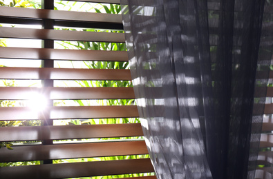Photo of Window with beautiful curtain and blinds, closeup
