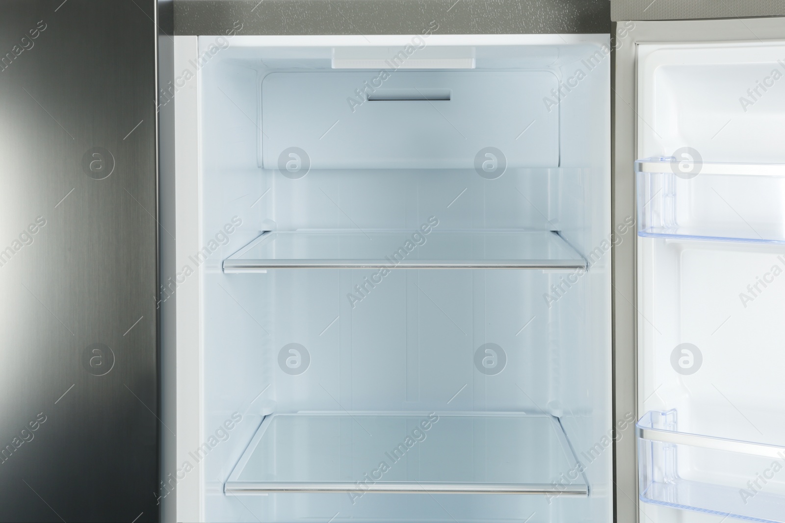 Photo of Shelves of empty modern refrigerator, closeup view