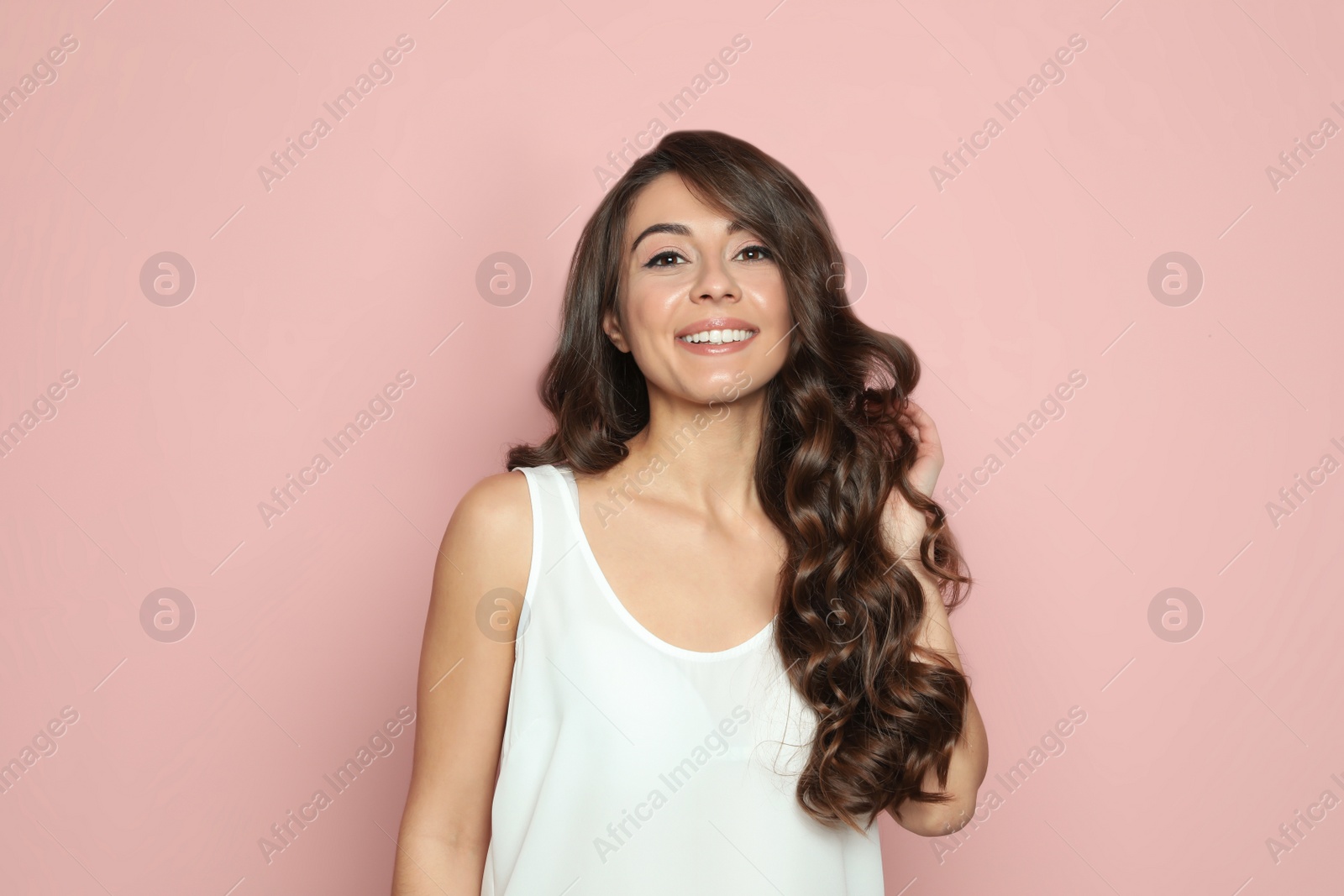 Photo of Beautiful woman with shiny wavy hair on color background