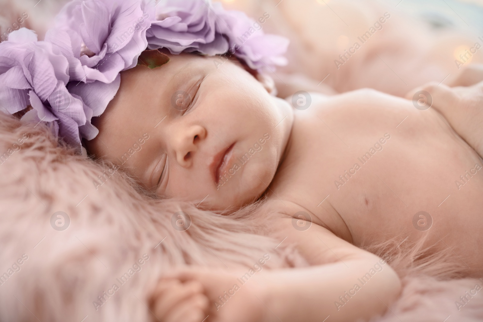 Photo of Adorable newborn baby girl with floral headband sleeping on bed