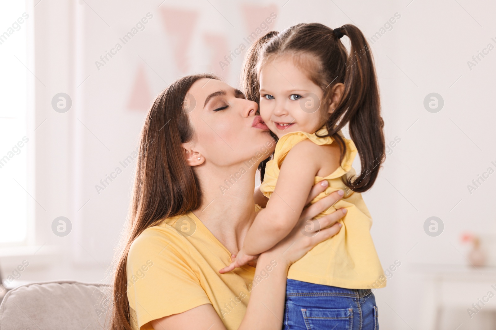 Photo of Young mother with little daughter at home