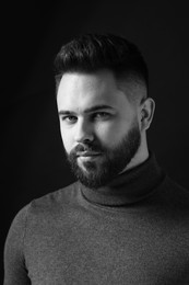 Photo of Portrait of handsome bearded man on dark background. Black and white effect