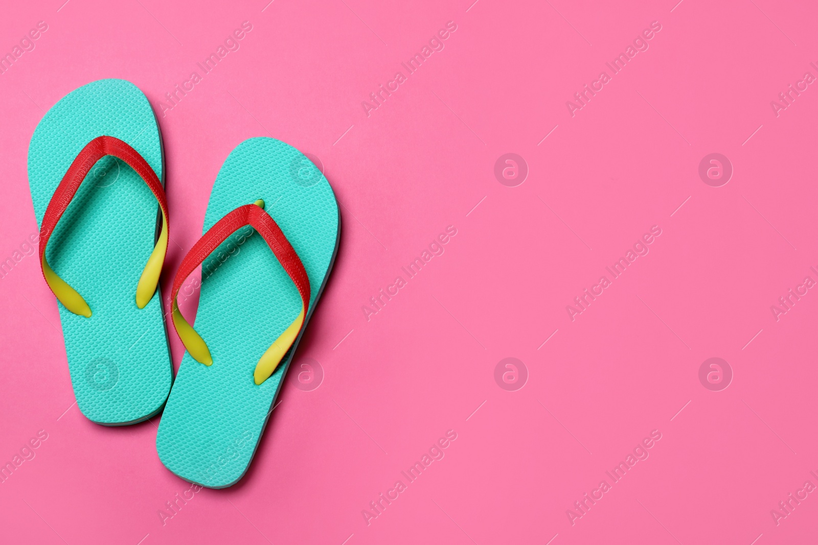 Photo of Stylish flip flops on pink background, flat lay. Space for text