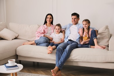 Photo of Happy family resting on comfortable sofa in living room