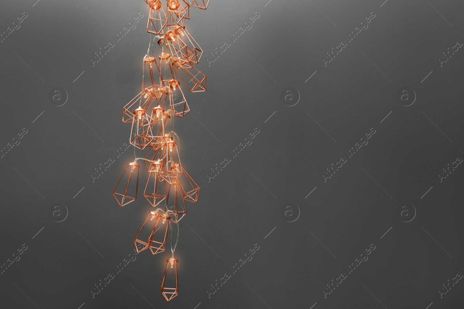 Photo of Garland of lamps with light bulbs on grey background. Space for text