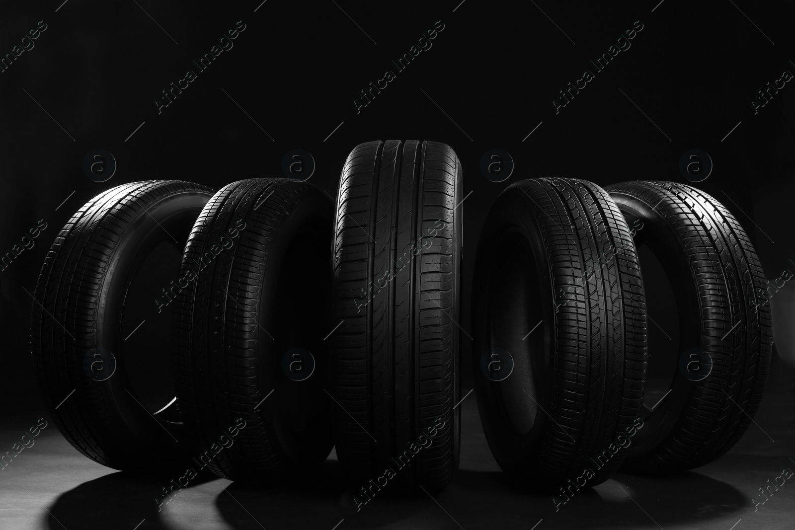 Photo of New car tires on black background