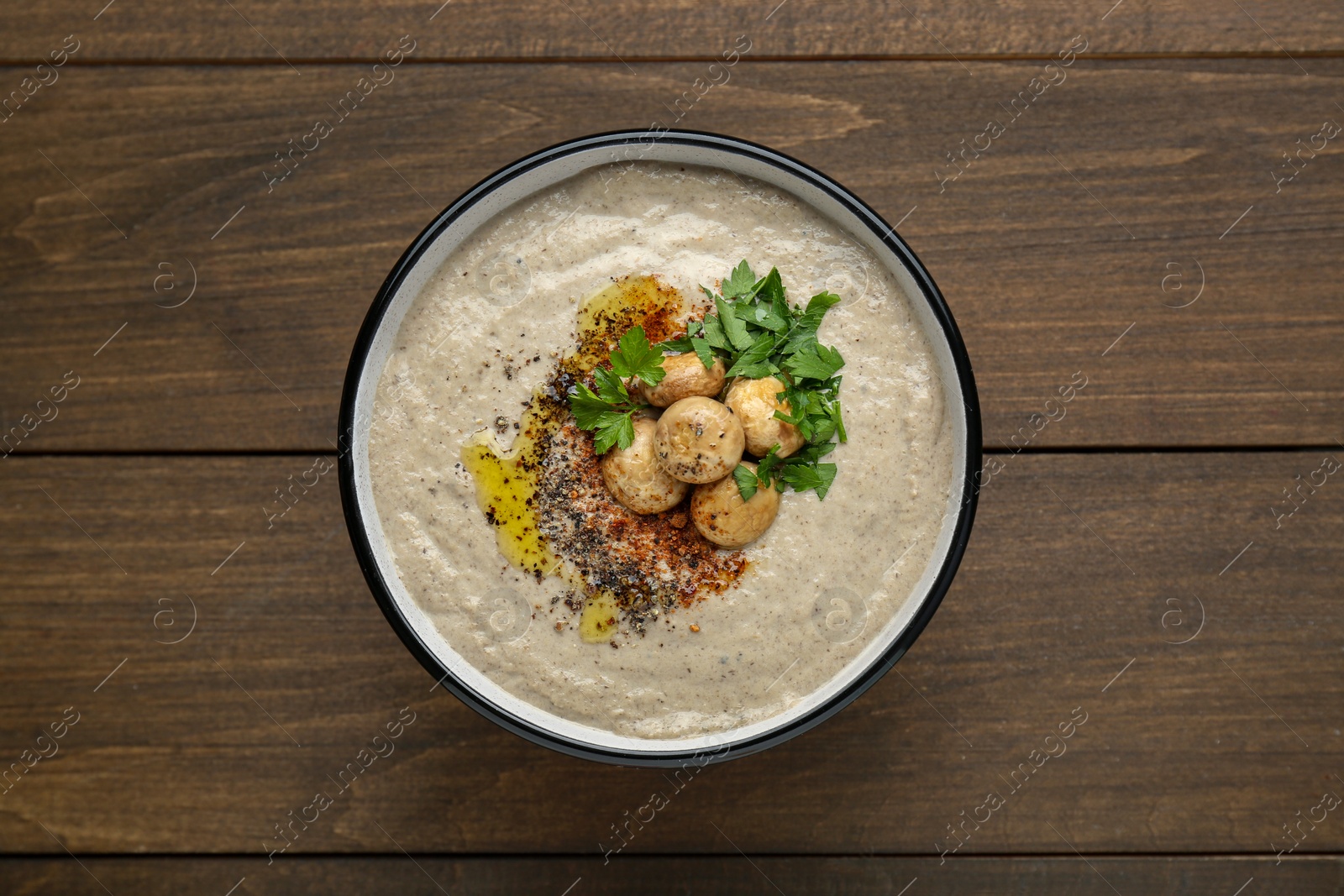 Photo of Delicious cream soup with mushrooms on wooden table, top view