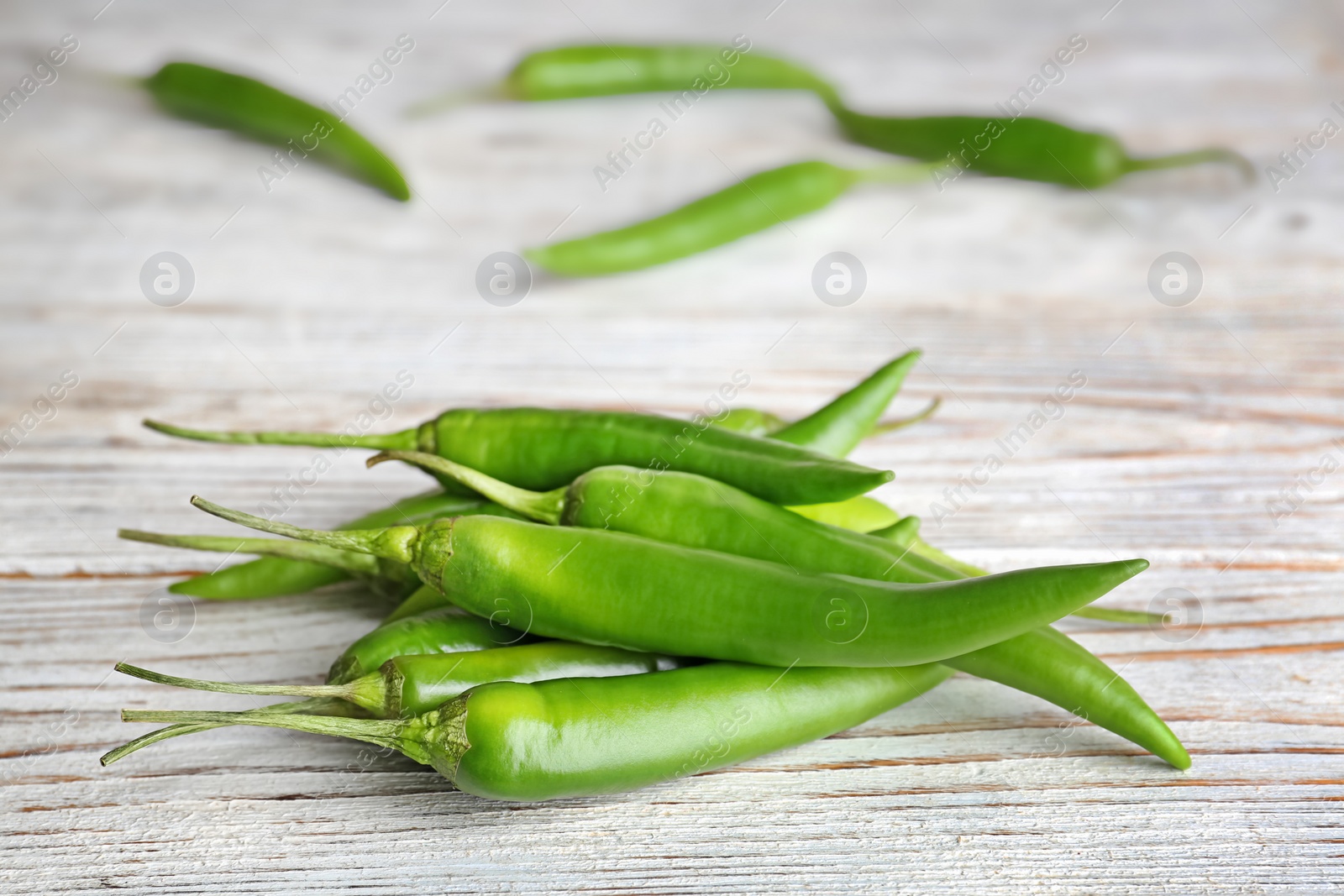 Photo of Pile of ripe chili peppers on wooden table