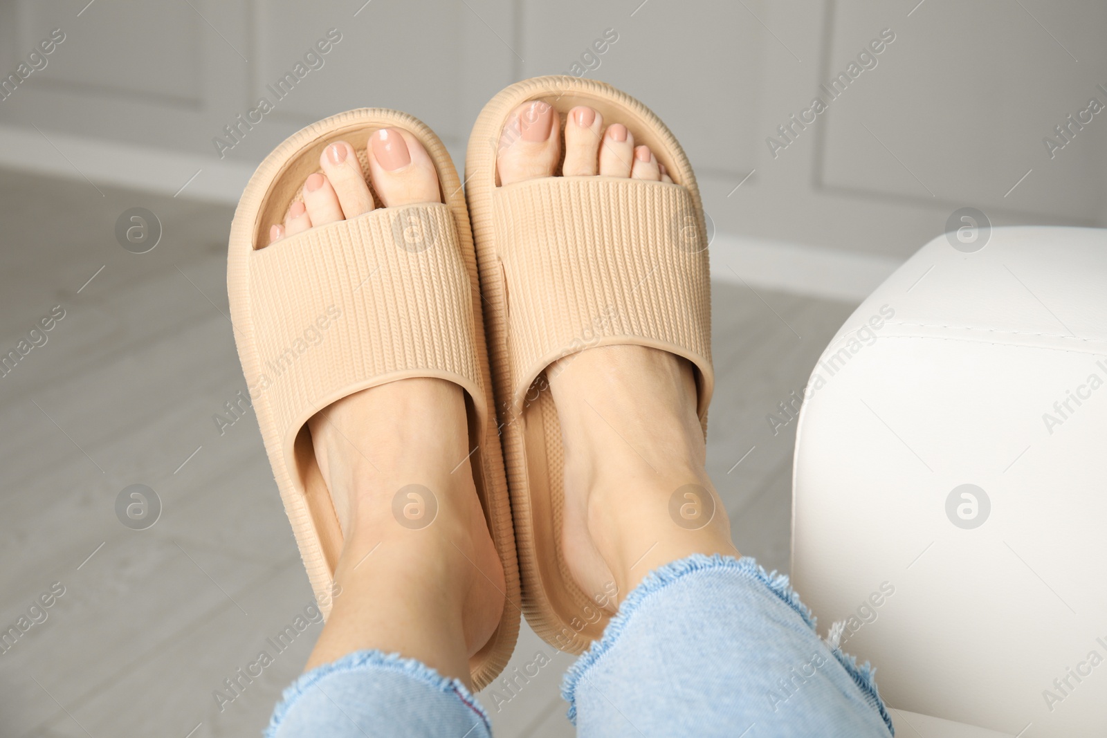 Photo of Woman wearing comfortable rubber slippers indoors, closeup
