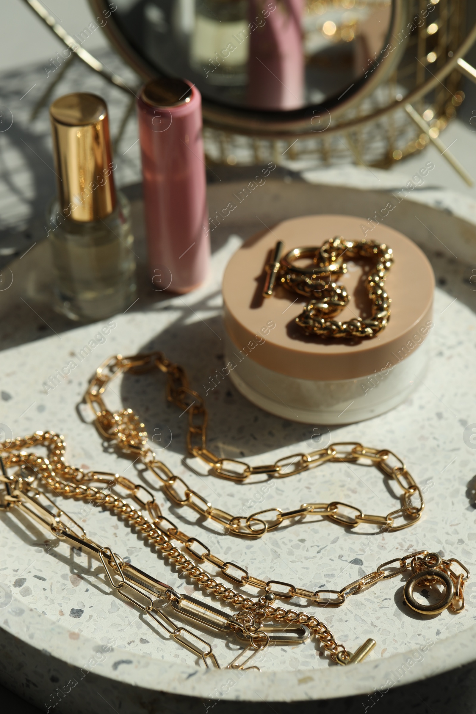 Photo of Metal chains and cosmetics on table. Luxury jewelry