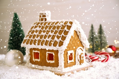 Photo of Beautiful gingerbread house decorated with icing on snow