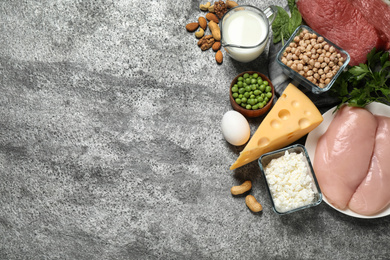 Photo of Products rich in protein on grey table, flat lay. Space for text