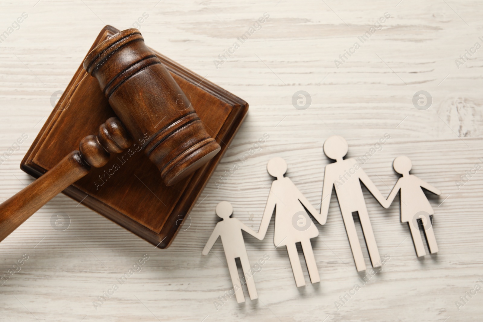 Photo of Law concept. Gavel and figures of parents with children on white wooden table, top view