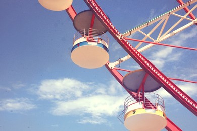 Image of Beautiful large Ferris wheel against blue sky, low angle view