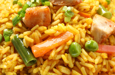 Delicious rice pilaf with chicken and vegetables as background, closeup