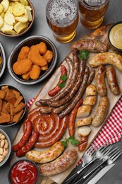Photo of Set of different tasty snacks and beer on dark grey table, flat lay
