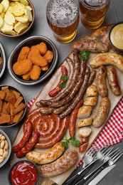 Set of different tasty snacks and beer on dark grey table, flat lay