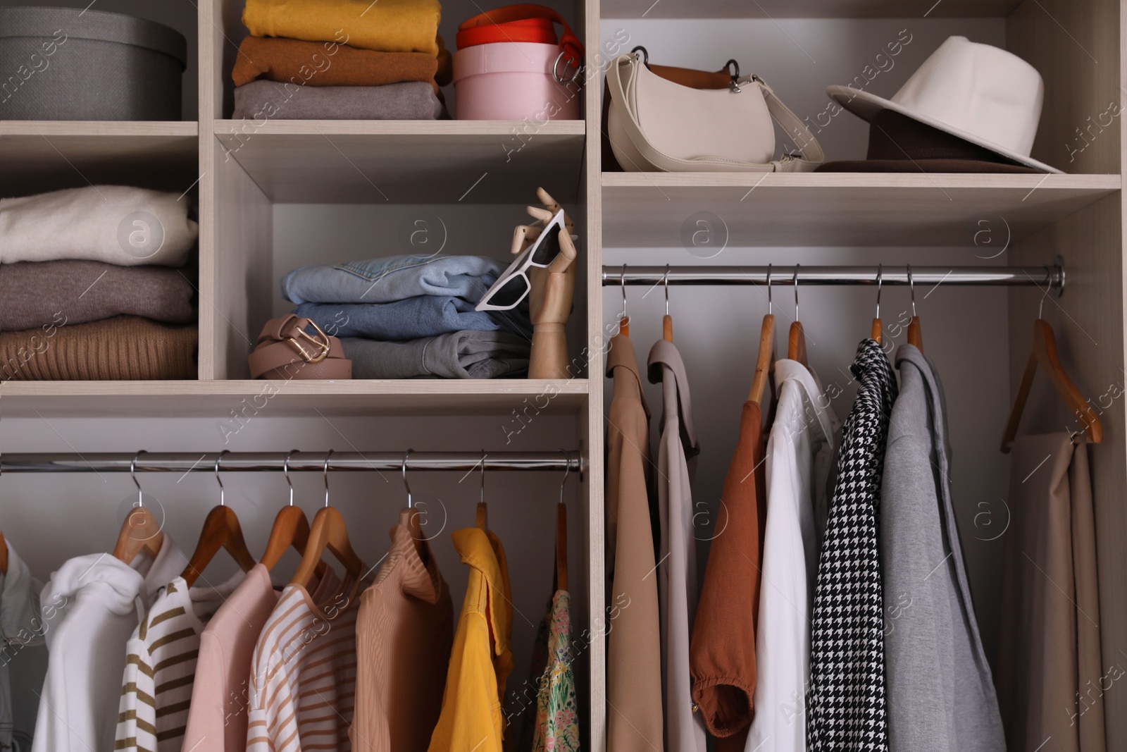 Photo of Wardrobe closet with different stylish clothes, accessories and home stuff