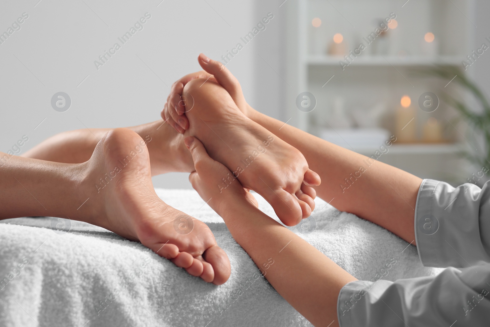 Photo of Woman receiving foot massage in spa salon, closeup