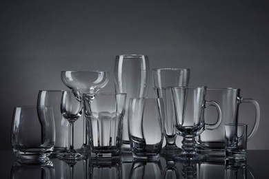Photo of Set of empty glasses on table against grey background